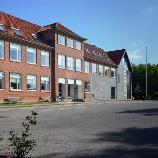 Facaden og hovedindgangen til Huset Give set fra p-pladsen.
