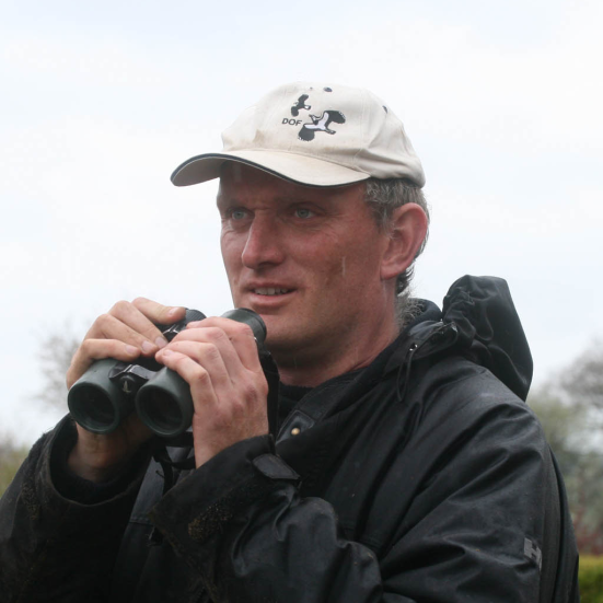 Foto af Morten D.D. Hansen i naturen med kikkert.