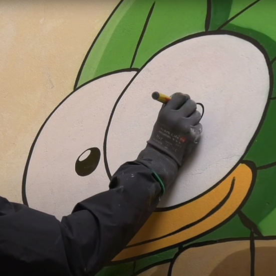 Mikkel Jessen tegner en fugl på en mur