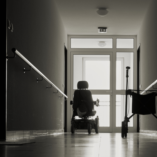 Kørestol og rolator foran vindue