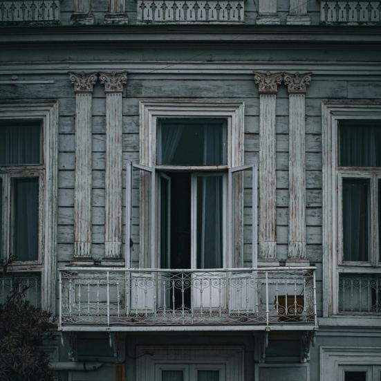 En mørk bygning med en åben terrassedør. 