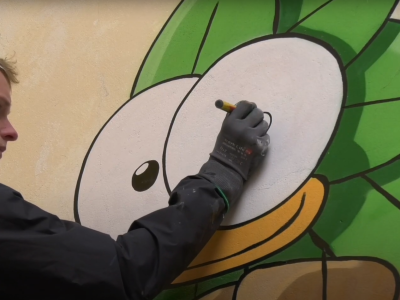 Mikkel Jessen tegner en fugl på en mur