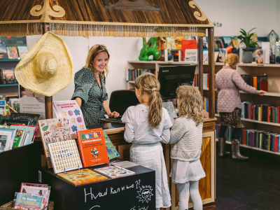 Medarbejder hjælper to piger på børnebiblioteket i Bryggen.
