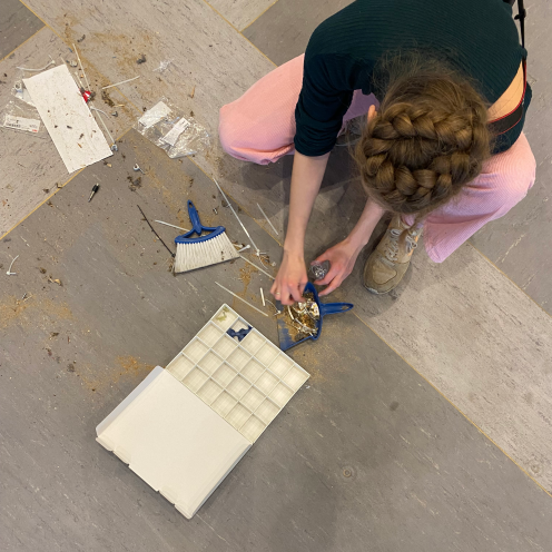 "Maria Viftrup gennemgår sammenfejet affald i tomt biblioteksrum.
