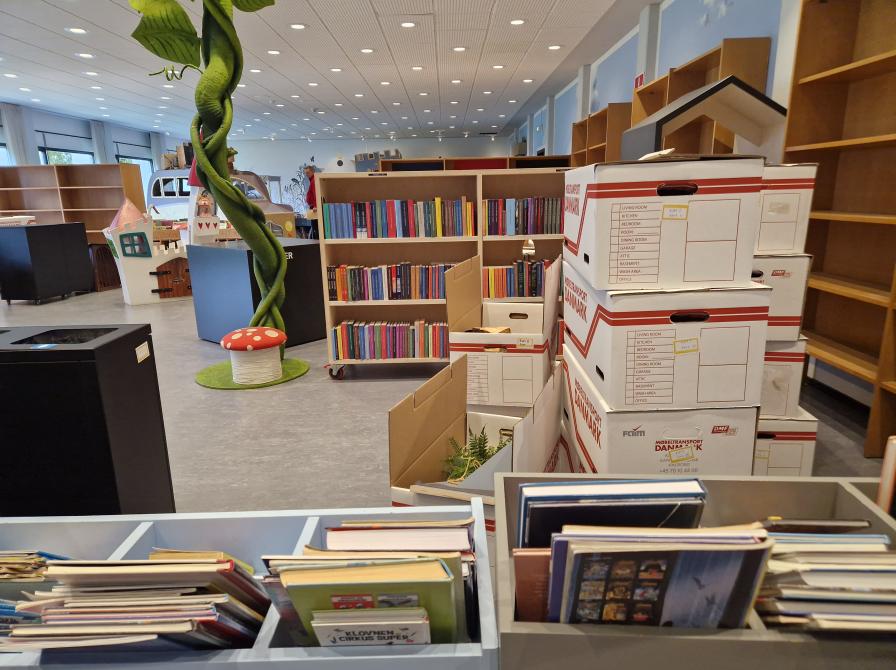 Et billede af børnebiblioteket, hvor der er en masse tomme reoler og nogle fyldte flyttekasser