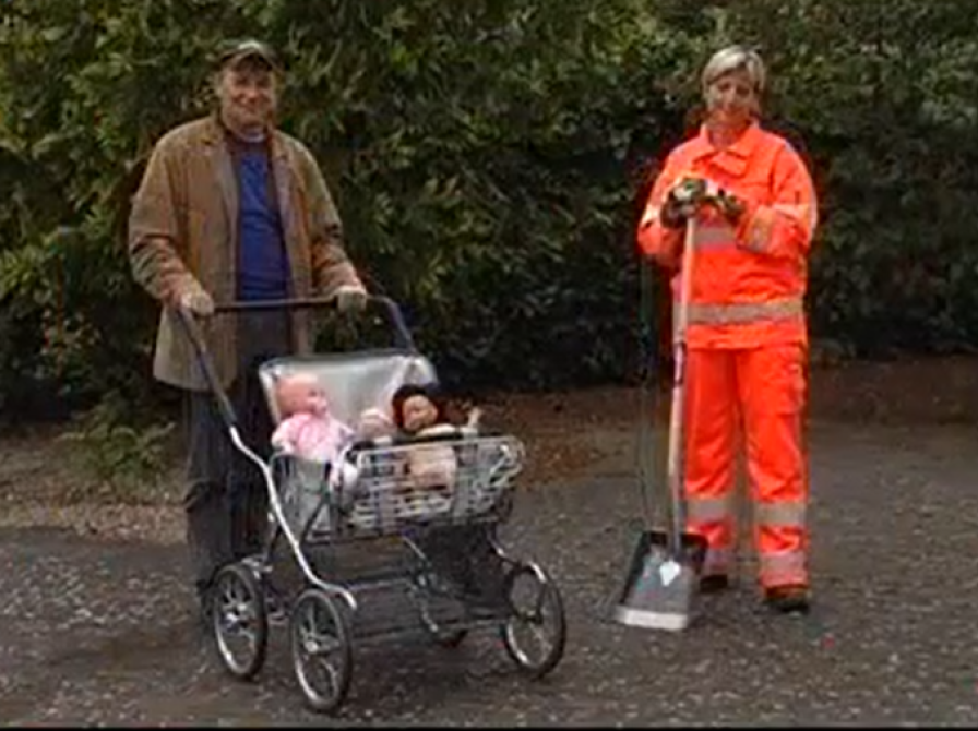 Mand med barnevogn og kvinde i orange arbejdstøj står ved siden af hinanden.