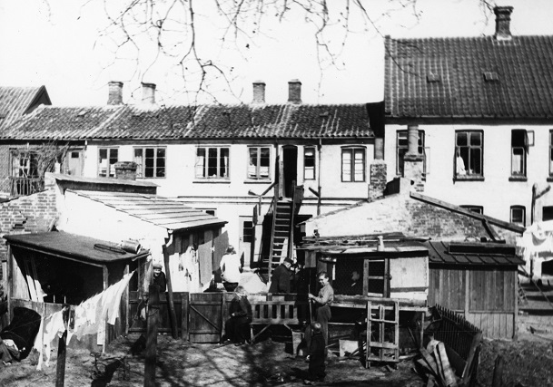 Vasketøj hænger til tørre ved Inger Christensens fødehjem på Gammelhavn 34 (set fra bagsiden ud mod Sønderåen)