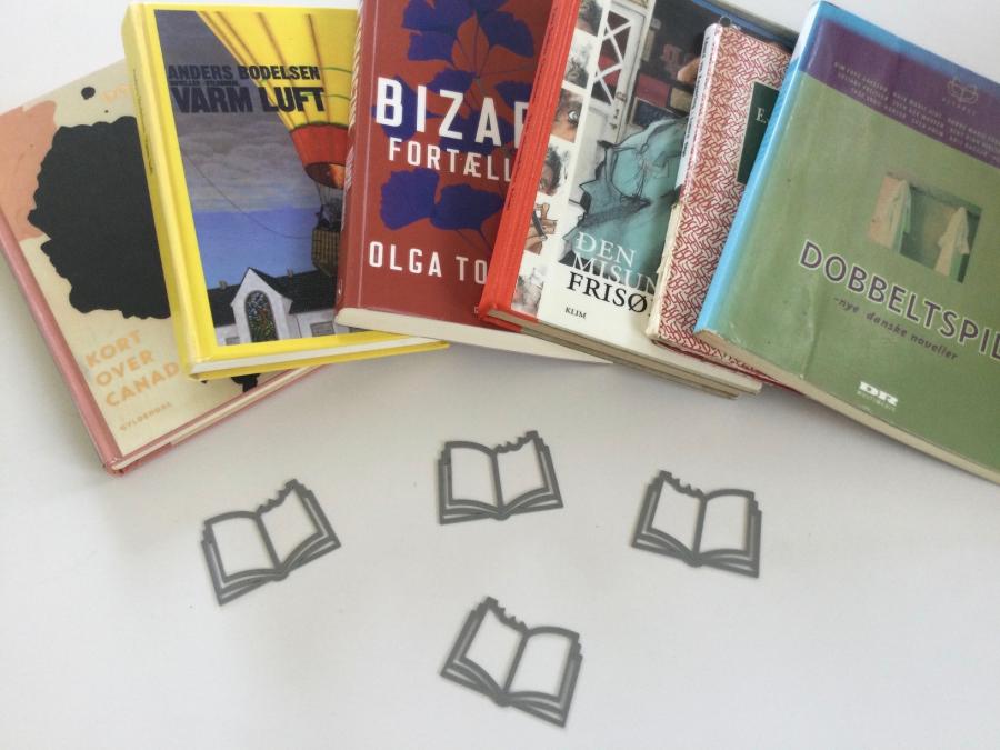 Seks bøger der ligger spredt ud på et bord