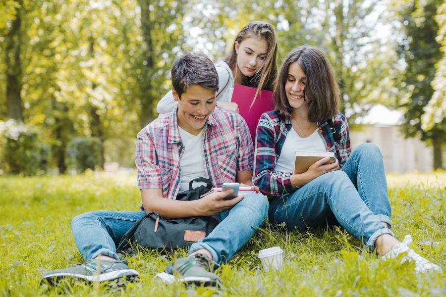 Teenager læser på græsplæne